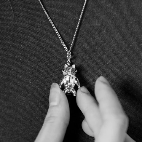 A necklace with a silver pendant on a neck