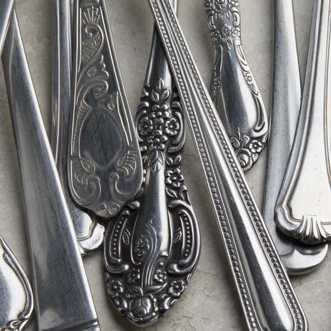 A silver pendant shaped like a parrot in a raincoat